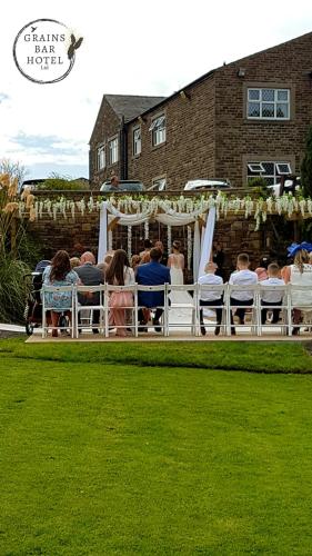 a group of people sitting in chairs at a wedding at Grains Bar Hotel in Oldham