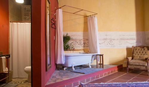 bagno con vasca, lavandino e sedia di Casa Maria Paz Hotel Boutique a Puebla