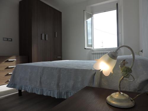 a bedroom with a bed and a lamp on a table at Casa Sterinella in Follo Alto
