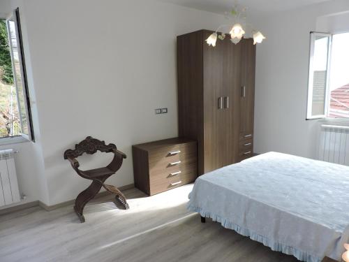 a bedroom with a bed and a wooden dresser at Casa Sterinella in Follo Alto
