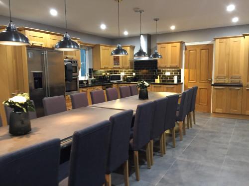 a large kitchen with a long table and chairs at Four Winds,Kinsale Town,Exquisite holiday homes,sleeps 26 in Kinsale