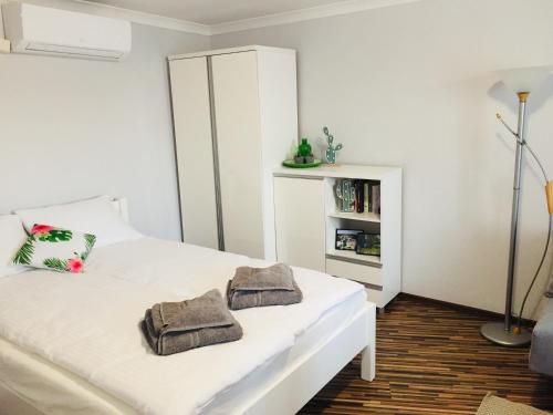 a bedroom with a white bed with towels on it at Apartament Na Starówce VII in Pszczyna