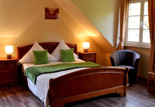 una camera da letto con un letto con cuscini verdi e una sedia di Hotel Athos a Baden-Baden