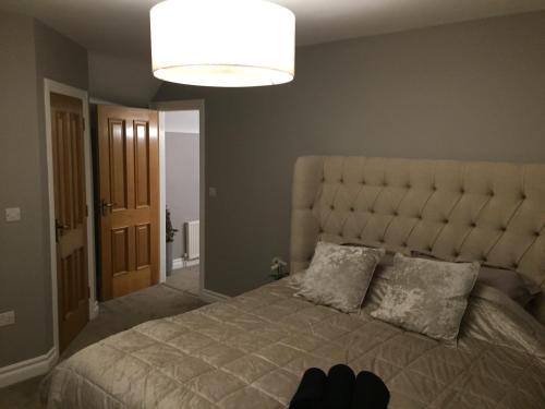 a bedroom with a large bed with a large headboard at Four Winds,Kinsale Town,Exquisite holiday homes,sleeps 26 in Kinsale