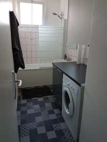 ein Badezimmer mit einer Waschmaschine und einer Badewanne in der Unterkunft Dunkerque Malo les bains 15 mn plage in Dunkerque