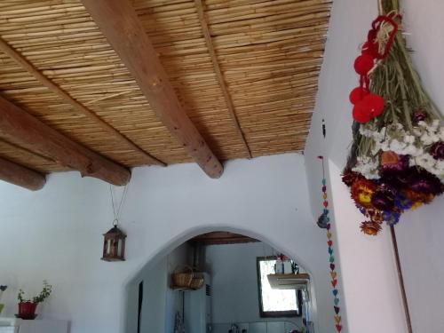 a room with a wooden ceiling with flowers on the wall at Cabaña El Cardón,casita en el campo quebradeño in Humahuaca