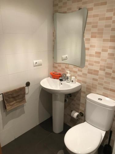 a bathroom with a white toilet and a sink at Hostal Las Eras in Cubillos del Sil