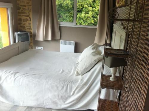 Schlafzimmer mit einem Bett mit weißer Bettwäsche in der Unterkunft Villa contemporaine in La Réorthe