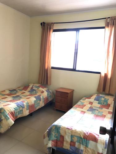 a bedroom with two beds and a window at Pacandé Apartamentos in Boquete