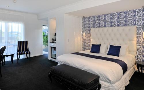 a bedroom with a large bed with a blue patterned wall at Black Swan Lakeside Boutique Hotel in Rotorua