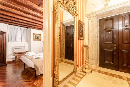 um quarto com um espelho e uma cama num quarto em Residenza Contessa Costanza em Roma