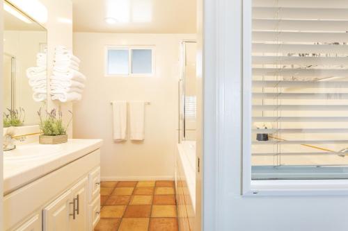 a bathroom with a shower and a sink and a mirror at The Sea View Inn At The Beach in Manhattan Beach