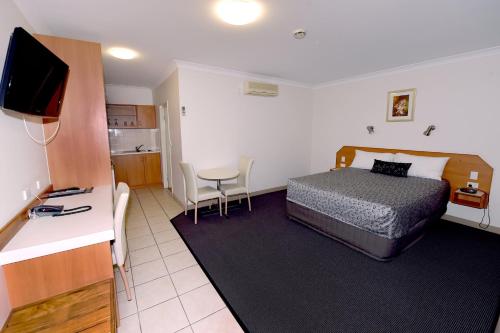 mały pokój hotelowy z łóżkiem i kuchnią w obiekcie Carriers Arms Hotel Motel w mieście Maryborough