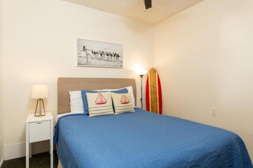 a bedroom with a blue bed and a surfboard at The Sea View Inn At The Beach in Manhattan Beach