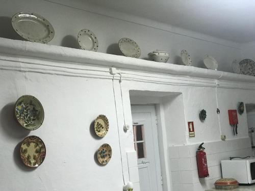a shelf with plates and plates on a wall at Casa dos Tios Estremoz-veiros in Veiros