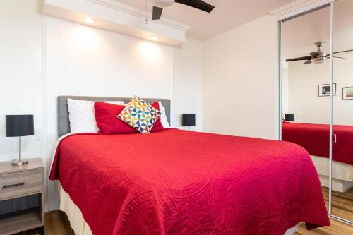 a bedroom with a red bed with a red blanket at The Sea View Inn At The Beach in Manhattan Beach