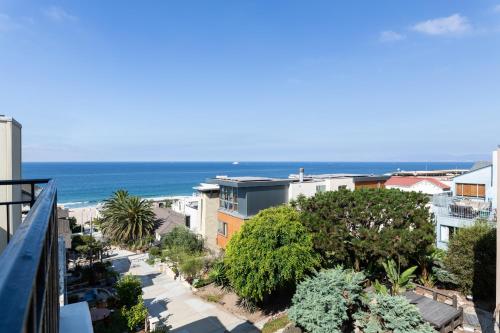 a view of the beach from the balcony of a building at The Sea View Inn At The Beach in Manhattan Beach