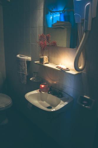 a bathroom with a sink and a mirror and a phone at Hotel Garden in San Miguel de Tucumán