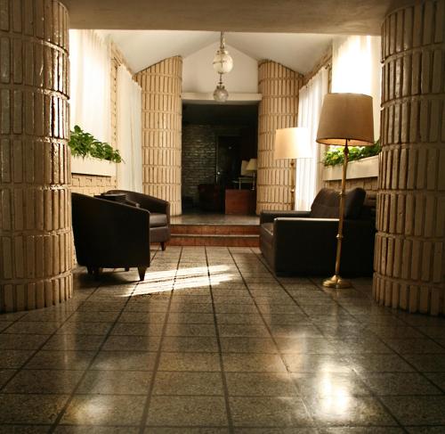 a living room with couches and a floor lamp at Hotel Garden in San Miguel de Tucumán