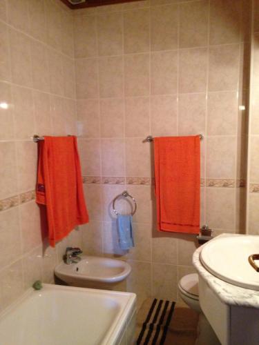 bagno con asciugamani arancioni, servizi igienici e lavandino di Casas do Trabulo a Decermilo