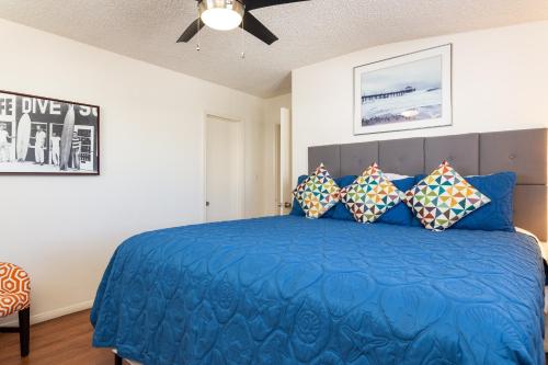 a bedroom with a blue bed with pillows at The Sea View Inn At The Beach in Manhattan Beach
