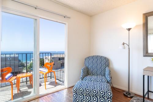 a living room with a chair and a balcony at The Sea View Inn At The Beach in Manhattan Beach