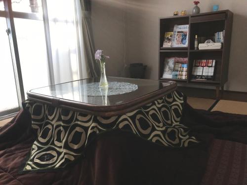a glass table with a vase on top of it at Yuigahama Apart in Kamakura
