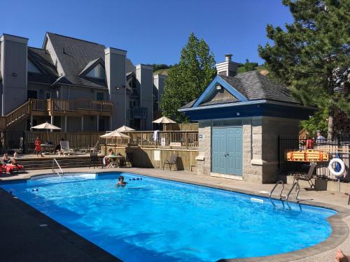 a person swimming in a large blue swimming pool at Blue Mountain Getaway at North Creek Resort King Bed in Blue Mountains