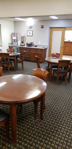 a room with tables and chairs and a kitchen at Super 8 by Wyndham Windsor in Windsor