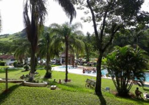 een park met palmbomen en een zwembad bij Camping Valle das Aguas in Socorro