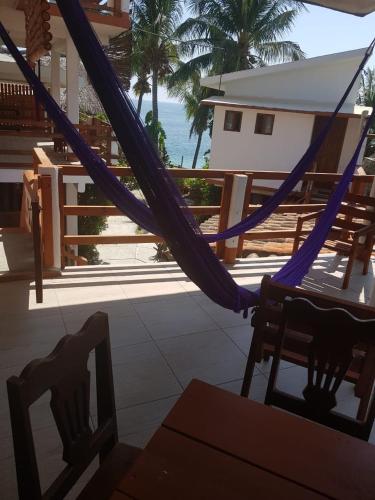 a hammock on a porch with a view of the ocean at Posada Ziga Playa in Mazunte
