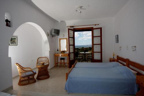 a bedroom with a bed and a table and chairs at Pirgos Naxos in Aliko Beach