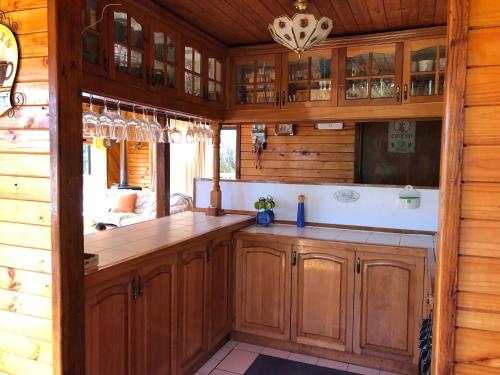 a kitchen with wooden cabinets and a counter top at Nuestracasa in Algarrobo