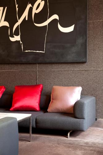 a living room with a couch with red pillows at Lancemore Mansion Hotel Werribee Park in Werribee