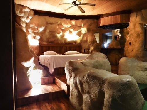 a bedroom with a bed in a room with rocks at El Gran Marques Hotel/Motel in Río Blanco