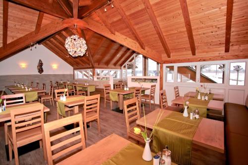a restaurant with wooden ceilings and tables and chairs at Hotel Pension Fent in Bad Füssing