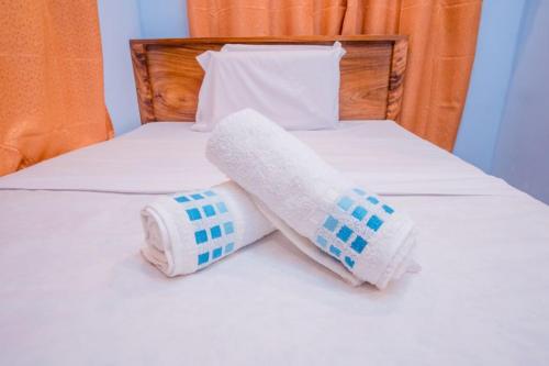 a pair of towels sitting on top of a bed at Argamosa Bayside Inn in Coron