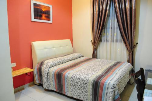 HOTEL MESRA ALOR SETAR في ألور سيتار: غرفة نوم صغيرة بها سرير ونافذة
