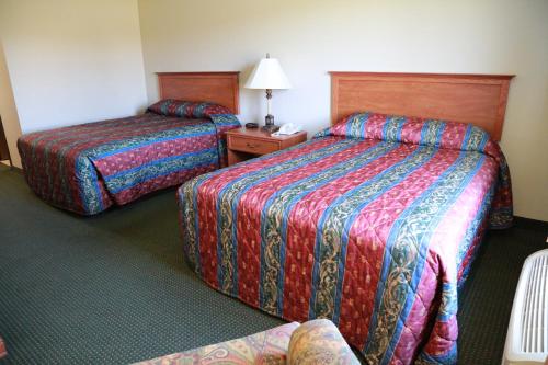 a hotel room with two beds and a table at Horizon Inn & Suites in West Point
