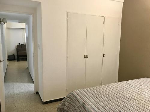 1 dormitorio con armario blanco y cama en Depto. c/balcón, Colón y Olavarría en Mar del Plata
