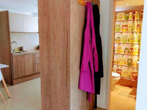 a pink jacket hanging on a wall in a kitchen at El más cool de la península. Gala Puerto. in Punta del Este