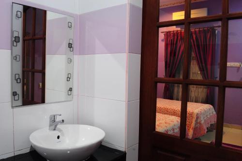 y baño con lavabo y espejo. en HOTEL MESRA ALOR SETAR en Alor Setar