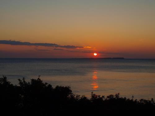 a sunset over the ocean with the sun in the sky at Niko Studios in Lassi