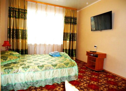 a bedroom with a bed and a tv and a window at Apartment 2Pillows Krasnoarmeyskaya in Chita