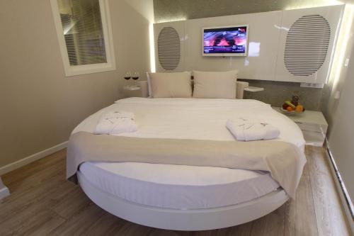 a bedroom with a large bed with a tv on the wall at Lale Hotel in Sapanca