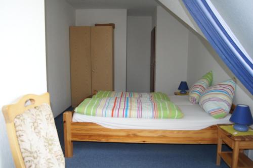 a small bedroom with a bed in a attic at Hotel Dorfkrug Büsum in Büsum
