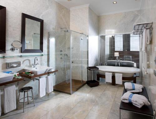 y baño con bañera, lavamanos y ducha. en Hotel URH Palacio de Oriol en Santurce