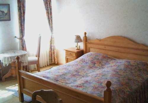 a bedroom with a wooden bed with a colorful blanket at Landhotel Krone in Königsbach Stein