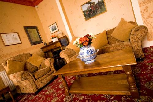 a living room filled with furniture and flowers at Nethercliffe Hotel in Wick
