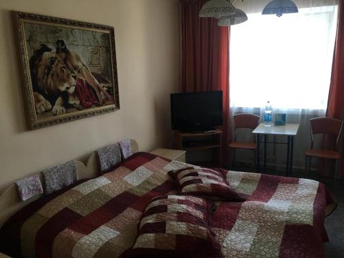 1 dormitorio con 1 cama y una pintura en la pared en Гостиница "Алем" Ерейментау, en Yermentau